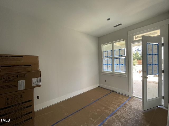 doorway with baseboards and visible vents