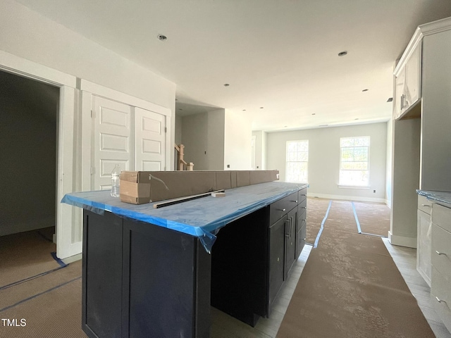 kitchen featuring a kitchen island and baseboards