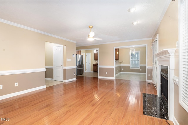 unfurnished living room featuring ceiling fan, a fireplace, wood-type flooring, and ornamental molding