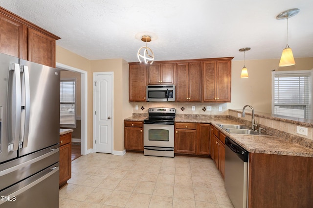 kitchen featuring sink, pendant lighting, decorative backsplash, light tile patterned flooring, and appliances with stainless steel finishes