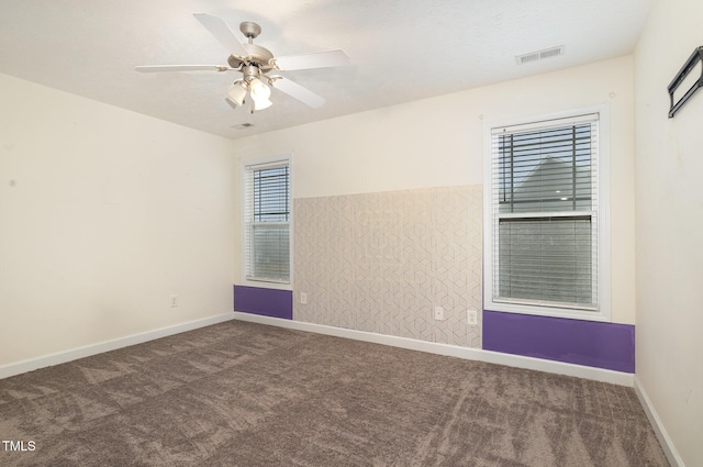 carpeted spare room featuring ceiling fan