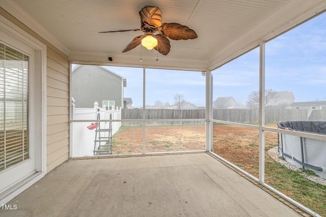 unfurnished sunroom with ceiling fan and plenty of natural light