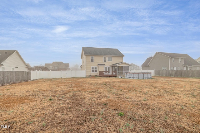 rear view of property featuring a pool side deck