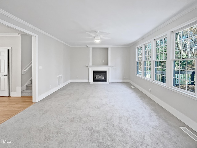 unfurnished living room with carpet, ceiling fan, and crown molding