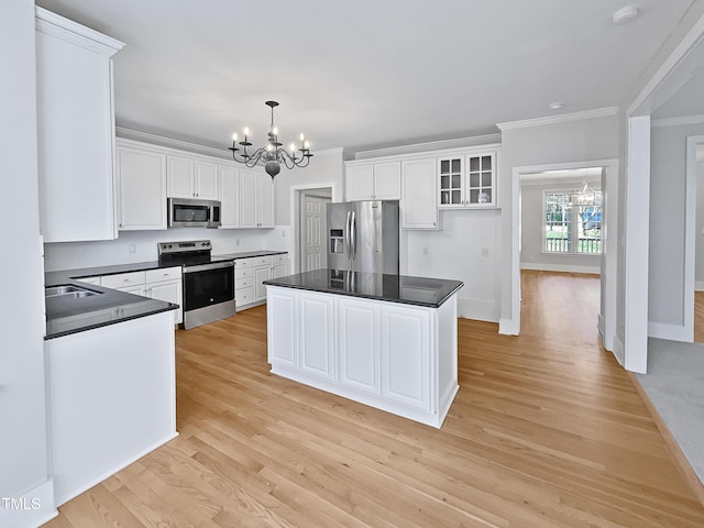 kitchen featuring white cabinetry, a center island, a chandelier, and appliances with stainless steel finishes