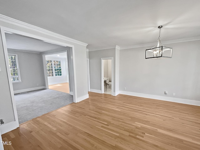 interior space featuring a notable chandelier, light wood-type flooring, and ornamental molding