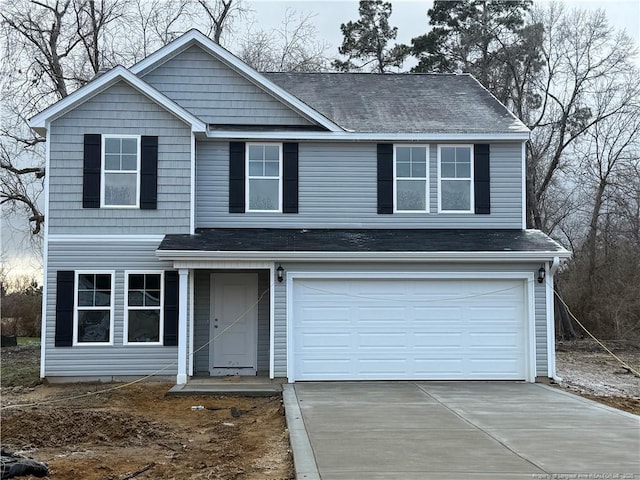 traditional-style house with a shingled roof, concrete driveway, and an attached garage