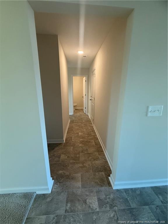 hall with stone finish floor and baseboards