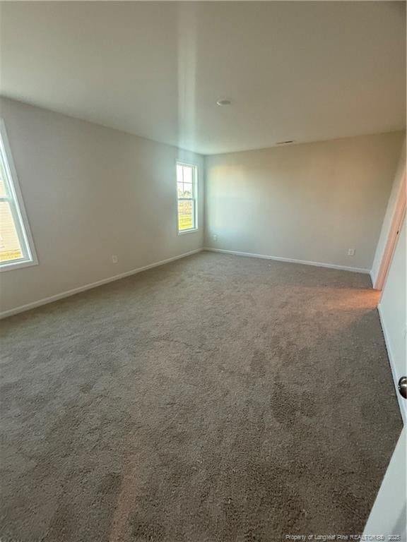 carpeted empty room with baseboards