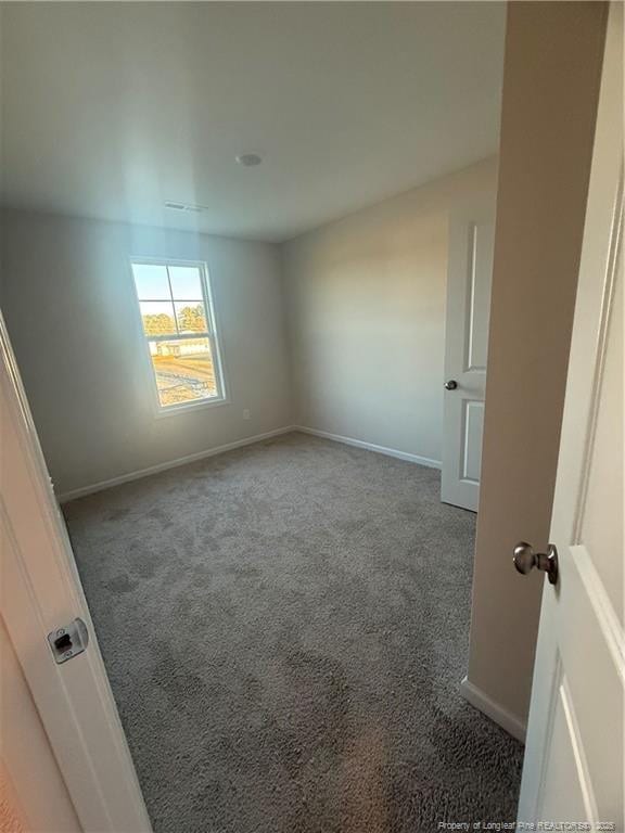 unfurnished bedroom with carpet floors and baseboards