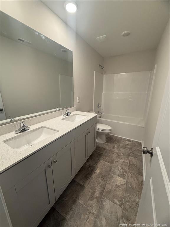 full bath with  shower combination, double vanity, a sink, and toilet