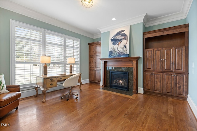 home office with a high end fireplace, plenty of natural light, ornamental molding, and hardwood / wood-style flooring