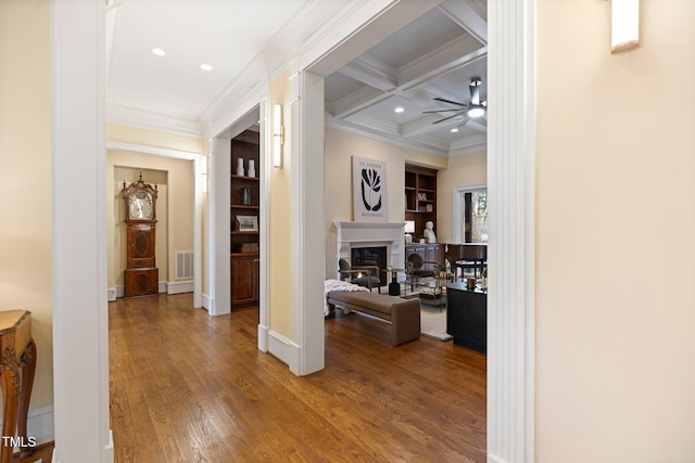 hall featuring beamed ceiling, crown molding, coffered ceiling, and hardwood / wood-style floors