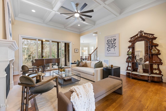 living room with coffered ceiling, hardwood / wood-style floors, crown molding, and beamed ceiling