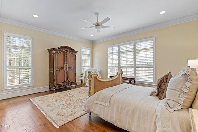 bedroom with multiple windows, hardwood / wood-style floors, ornamental molding, and ceiling fan