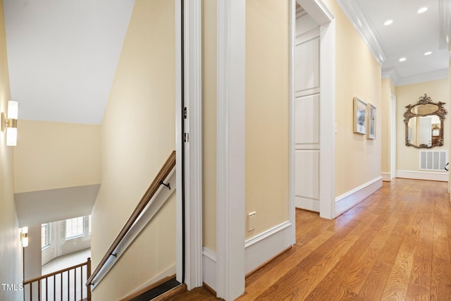 hall with crown molding and light hardwood / wood-style flooring