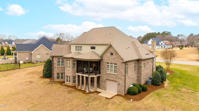 rear view of property with a garage and a yard