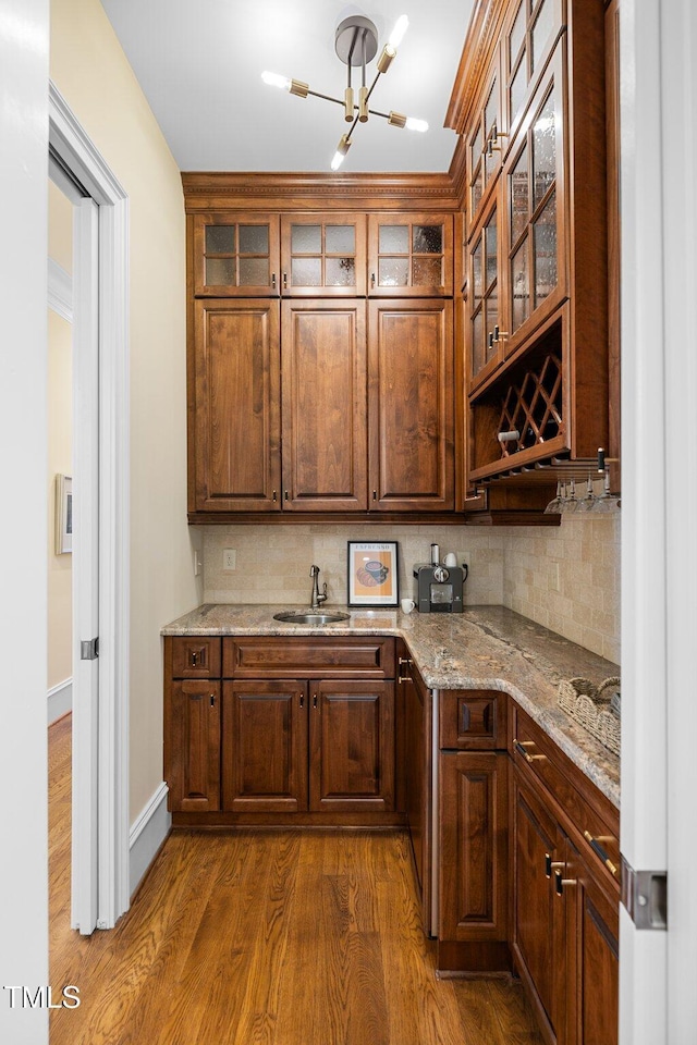 101 Bonica Creek Dr, Garner, NC 27529 - kitchen with an inviting chandelier, light stone countertops, dark wood-type flooring, tasteful backsplash, and a sink