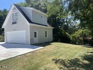 view of side of home with a yard and a garage