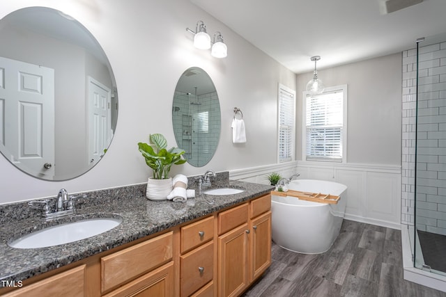 bathroom featuring vanity, hardwood / wood-style flooring, and plus walk in shower