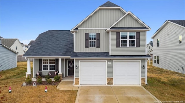 view of front of house with a garage, a front lawn, and a porch