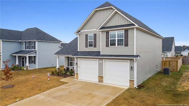 view of front of home with a front lawn, central AC, and a garage