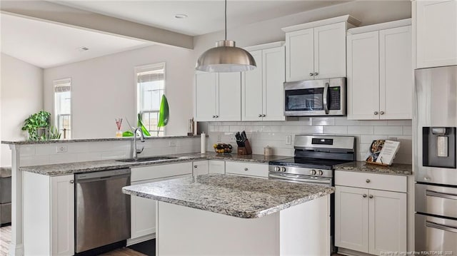 kitchen with decorative backsplash, sink, white cabinetry, and appliances with stainless steel finishes