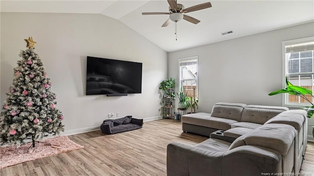 living room featuring ceiling fan, lofted ceiling, and light hardwood / wood-style flooring