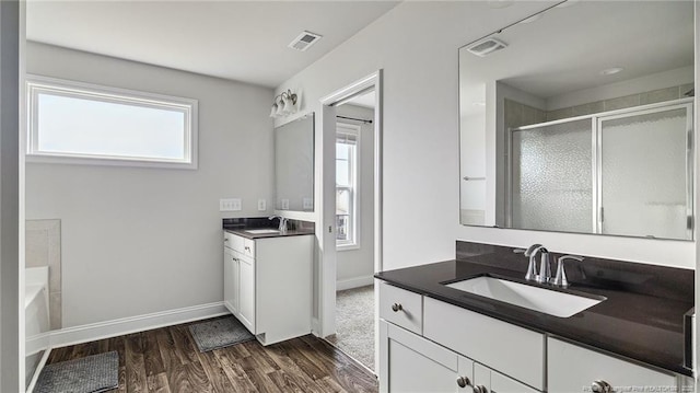 bathroom with separate shower and tub, vanity, and wood-type flooring