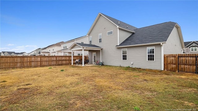 rear view of property featuring a lawn and a patio