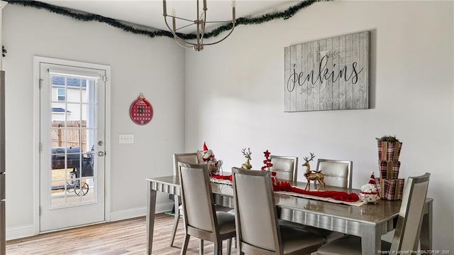 dining area featuring wood-type flooring and a chandelier