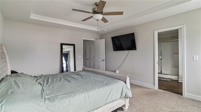 bedroom featuring ceiling fan, a raised ceiling, carpet floors, a closet, and a walk in closet