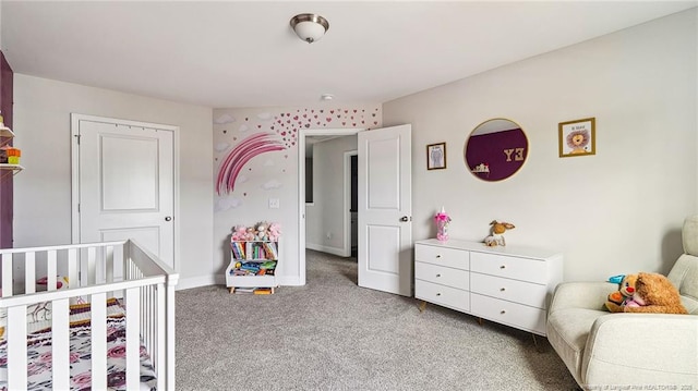 bedroom with light colored carpet and a nursery area