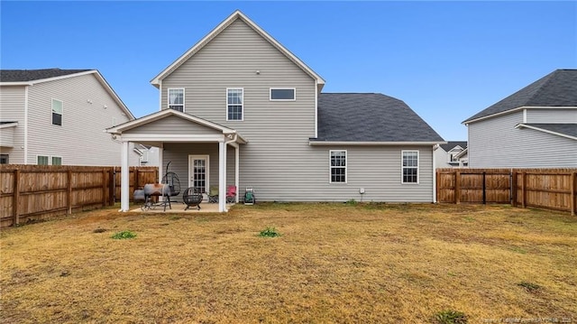 rear view of house featuring a yard and a patio