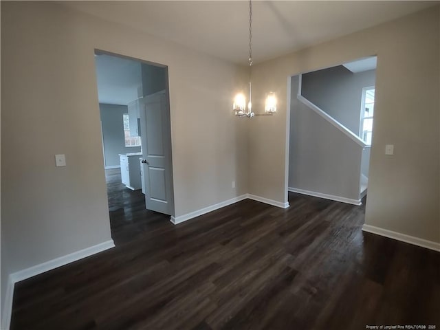 unfurnished dining area with dark hardwood / wood-style flooring and a chandelier