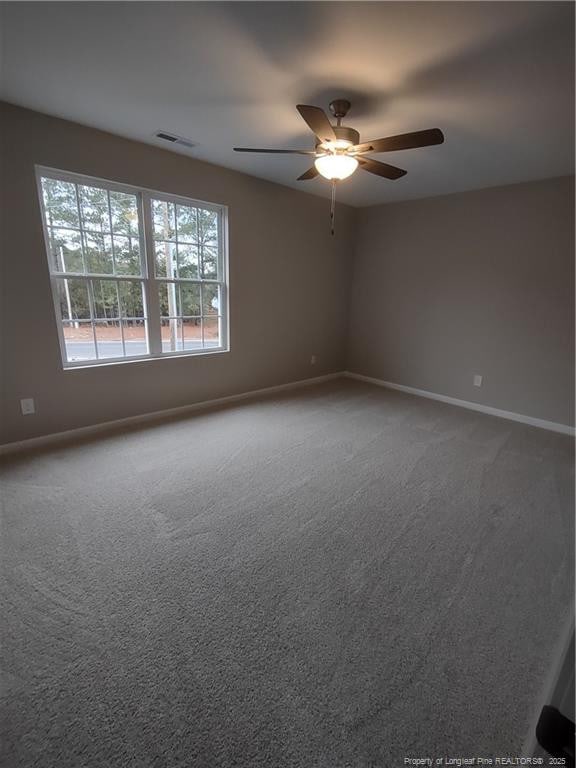 carpeted spare room featuring ceiling fan