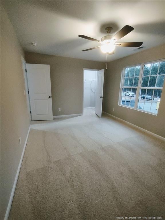 unfurnished room with carpet and ceiling fan