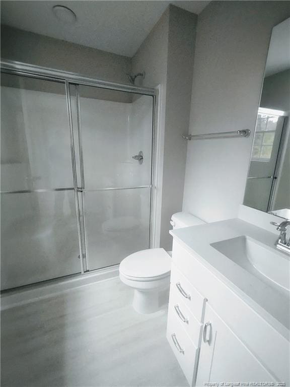 bathroom featuring vanity, toilet, and walk in shower