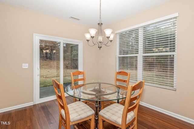 dining room with an inviting chandelier, baseboards, visible vents, and dark wood-style flooring