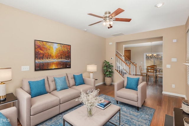 living area with stairway, wood finished floors, and baseboards