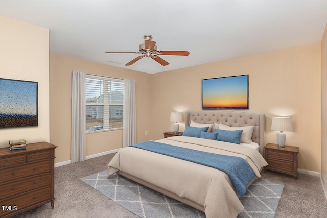 bedroom with light colored carpet, ceiling fan, and baseboards