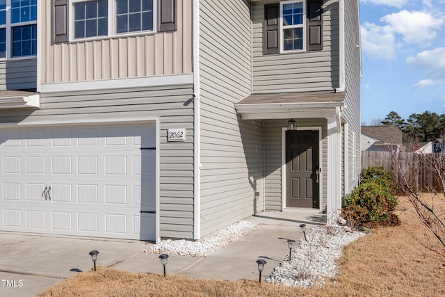 view of exterior entry featuring board and batten siding and an attached garage