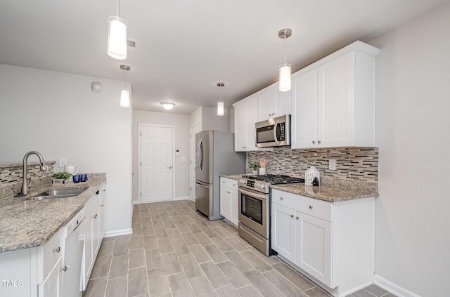 kitchen with tasteful backsplash, white cabinetry, stainless steel appliances, and a sink