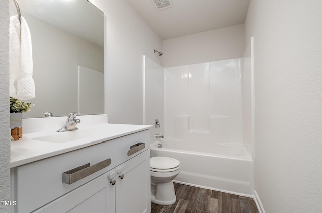 full bath with visible vents, toilet, wood finished floors,  shower combination, and vanity