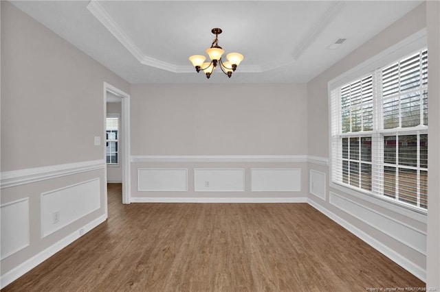 unfurnished room featuring dark wood-type flooring, a tray ceiling, and a chandelier