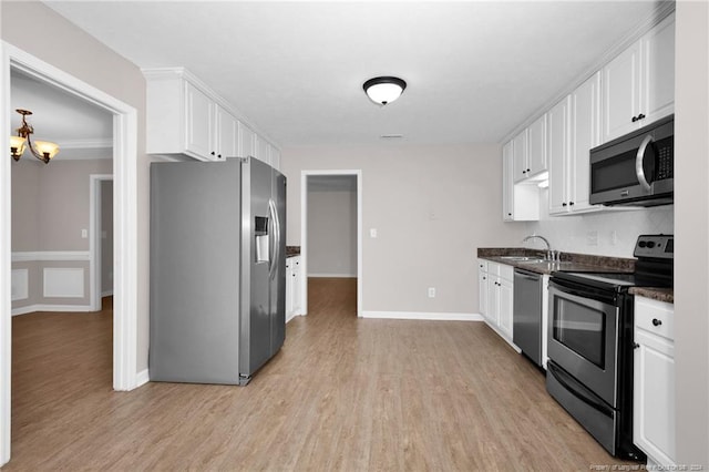 kitchen featuring white cabinetry, sink, stainless steel appliances, crown molding, and light wood-type flooring