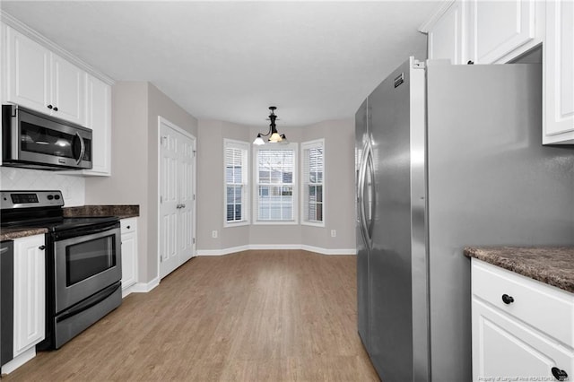 kitchen featuring white cabinetry, stainless steel appliances, and an inviting chandelier