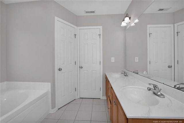 bathroom featuring tile patterned floors, a bathtub, and vanity