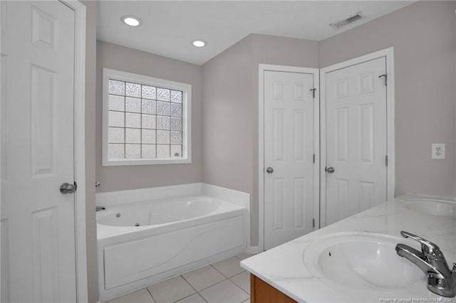 bathroom with tile patterned flooring, a bath, and vanity