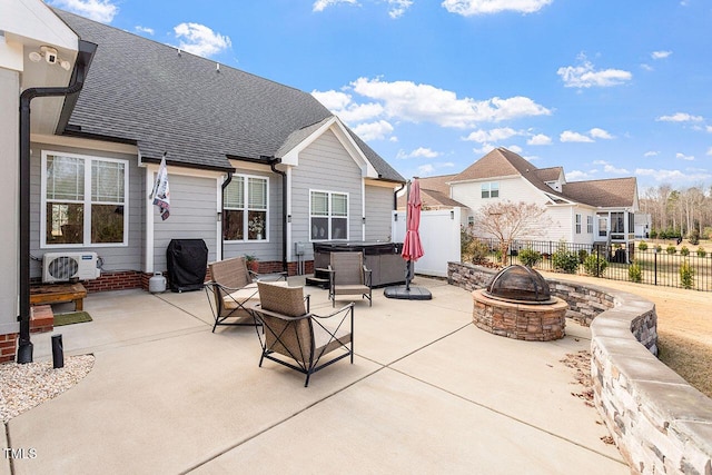 rear view of house featuring ac unit, a patio, a hot tub, and an outdoor fire pit